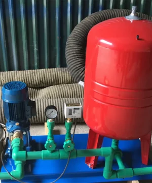Bình tích áp màu đỏ nối với máy bơm, đồng hồ áp suất và đường ống